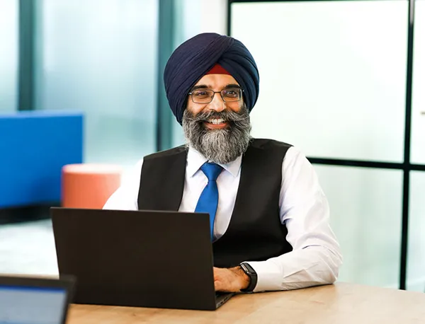 A man smiles in an brightly lit meeting room setting