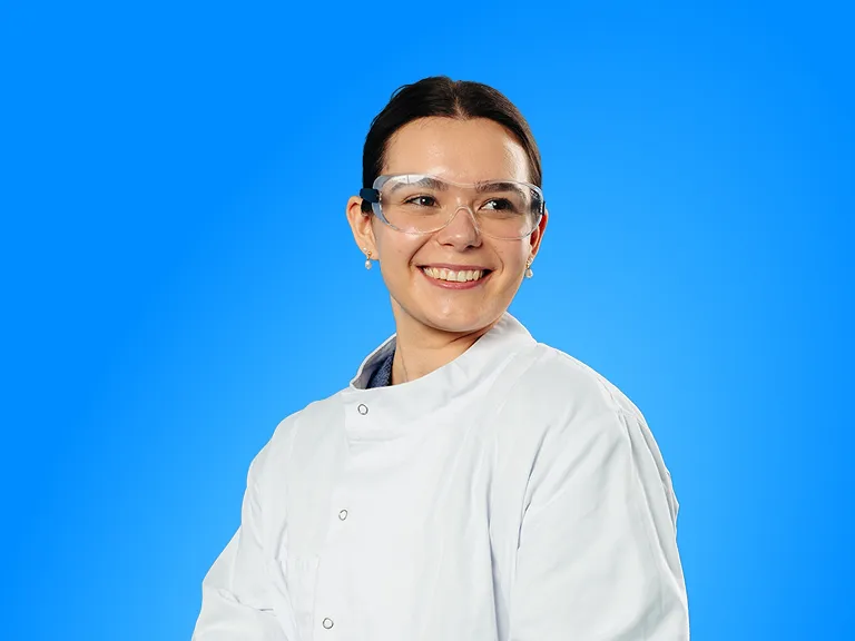 A Woman Wearing a Lab Coat and Glasses, Focused on Her Work in a Laboratory Setting