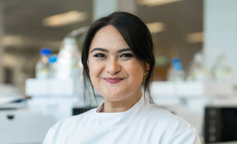 Portrait shot of a woman in a lab coat smiling to camera