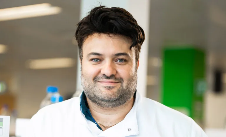 Portrait shot of a man in a lab coat smiling to camera