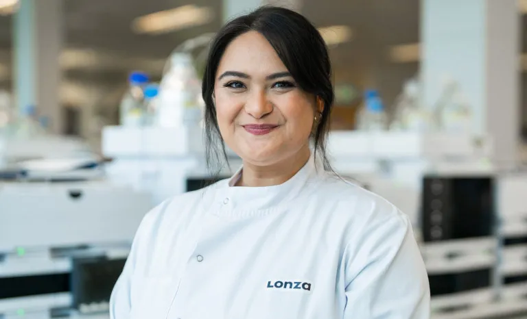 Emma wears a lab coat as she smiles directly to camera