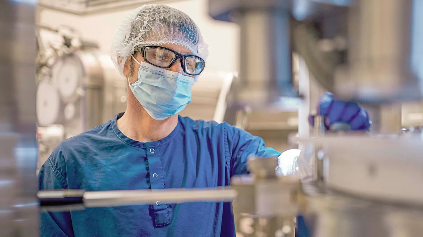 Man in Hairnet Goggles and Mask Working in Production Environment