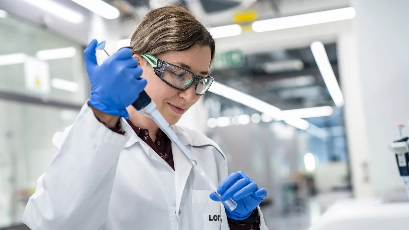 Female Scientist With Safety Goggles Using Pipette and Test Tube